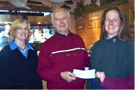 Ron Kobli hands fundraising check to Mercer County Wildlife Center representatives